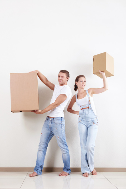 Um jovem casal segura caixas no apartamento
 - Foto, Imagem