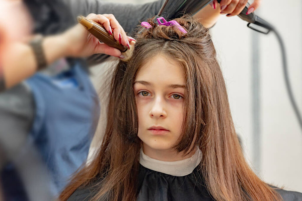 Gelukkig meisje dat haar haar laat knippen. Een serie foto 's van een meisje die haar haar laten knippen. kapsel, meisje, - Foto, afbeelding