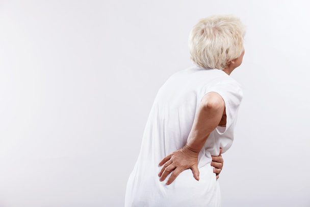 An elderly woman with back ache - Фото, зображення