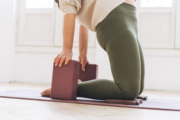 Attraente donna di mezza età in abbigliamento sportivo ptactice yoga con attrezzature in studio leggero - Foto, immagini