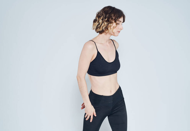 Frau in Leggings macht Übungen vor hellem Hintergrund Ausschnitt aus Fitnessturnen - Foto, Bild