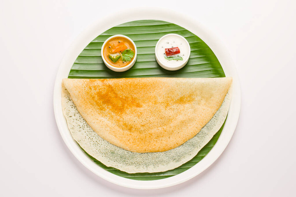 白を基調としたバナナの葉が並ぶ白い皿に、笑顔のように美しく盛り付けられた南インドのメイン朝食アイテム「グヒロストドサ」. - 写真・画像