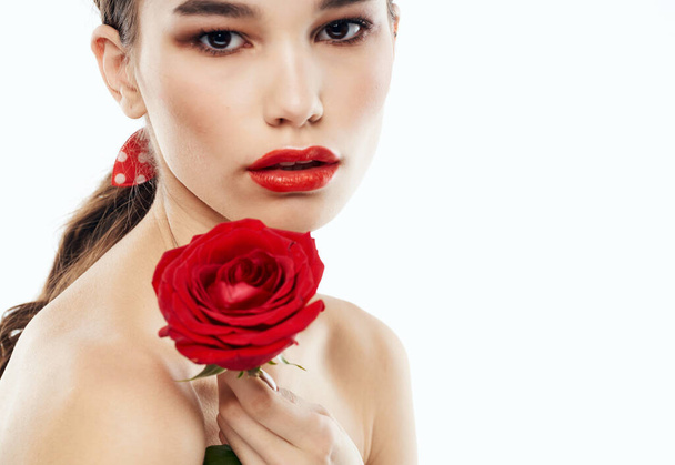 Young lady with bare shoulders and and a red flower near her face - Foto, Imagem