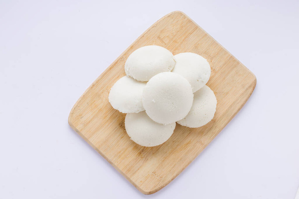Idly or Idli, south indian main breakfast item which is beautifully arranged in a wooden base with white background. - Photo, Image