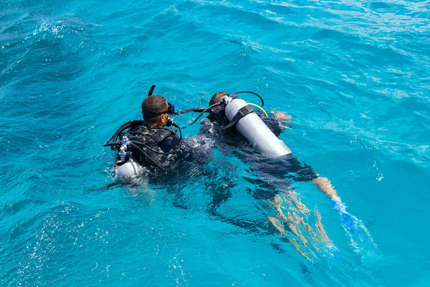 O início do mergulho com um instrutor nas águas do Mar Vermelho, o primeiro mergulho conjunto, treinamento de respiração correta debaixo d 'água - Foto, Imagem