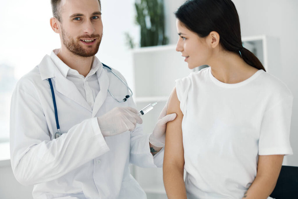 Profesyonel doktor, kadın hastaların omzuna aşı enjekte ediyor. - Fotoğraf, Görsel
