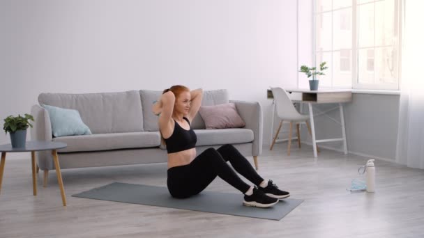 Femme sportive s'exerçant avec haltères bras flexibles muscles assis à l'intérieur - Séquence, vidéo