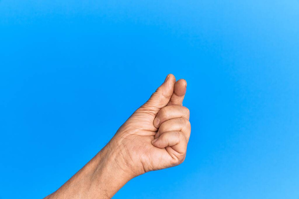 年上のパニック男の手上の青隔離された背景保持空白スペースとともに親指指,ビジネスと広告  - 写真・画像