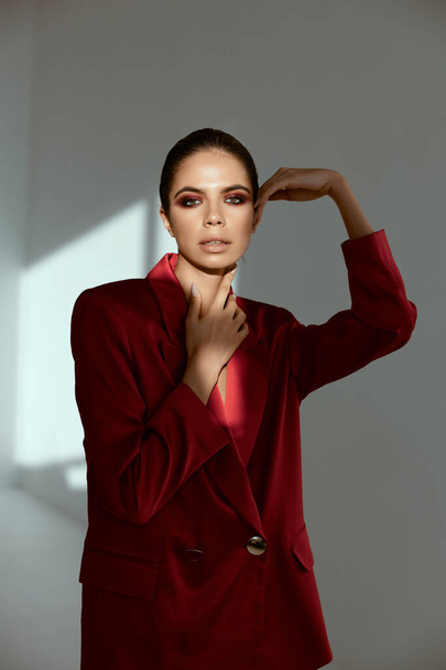 kobieta z jasnym makijażem na twarzy czerwony płaszcz dekoracji luksusowy model - Zdjęcie, obraz