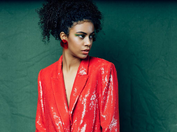 fashionable woman in red jacket with earrings and curly hair mulatto - Foto, imagen