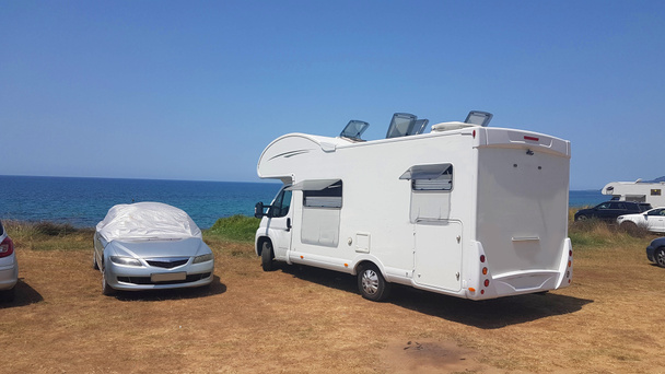 caravana remolque coche junto al mar en vacaciones de verano soleado día caluroso - Foto, Imagen