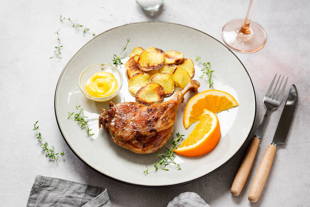 Pato pierna confit servido con papas fritas y salsa de mostaza. Cocina tradicional francesa. - Foto, imagen