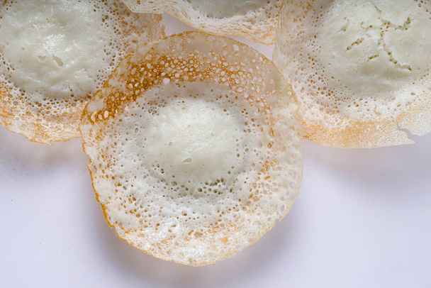 生の米を使用して作られ、白の背景に置かれた卵と非卵のカレーのための良い組み合わせで作られた、南インドやマラバール地域でおいしい朝食のアイテム、アップルまたはベラパムまたはカラパム、. - 写真・画像