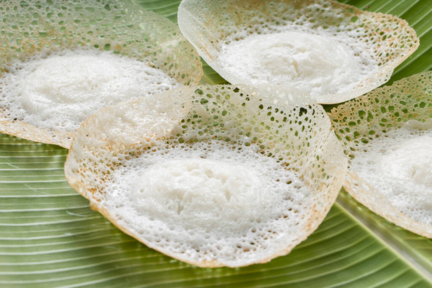 生の米を使用し、白を背景とした新鮮な緑のバナナの葉の上に置かれ、卵と非卵のカレーのための良い組み合わせを使用して作られた、南インドやマラバール地域でおいしい朝食アイテム、アッパムやベラパムやカラッパム、. - 写真・画像