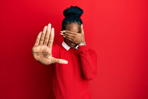 Young african american woman wearing casual clothes and glasses covering eyes with hands and doing stop gesture with sad and fear expression. embarrassed and negative concept.  - Photo, Image