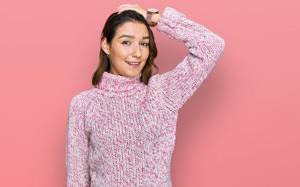 Young caucasian girl wearing wool winter sweater smiling confident touching hair with hand up gesture, posing attractive and fashionable  - Foto, Imagen