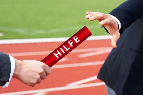 Biznesmeni przekazują pałeczkę pomocniczą w niemieckim wyścigu sztafetowym Hilfe na stadionie - Zdjęcie, obraz
