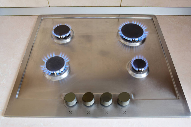 Kuchnia kuchenka gazowa z czterema palnikami spalającymi niebieski płomień - Zdjęcie, obraz