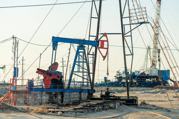 Насосная установка в виде нефтяного насоса, установленного на скважине. Оборудование нефтяных месторождений Азербайджана - Фото, изображение