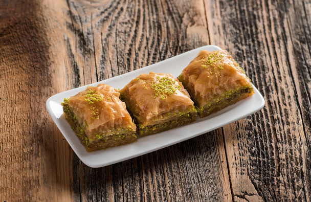 BAKLAVA. Desserts traditionnels turcs Baklava. Baklava aux pistaches croustillantes sur fond en bois. - Photo, image
