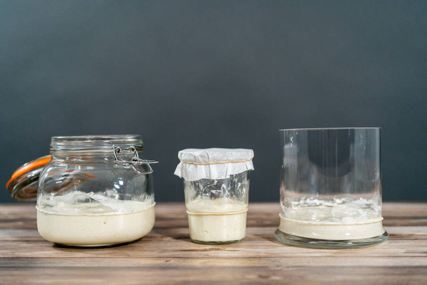 Alimentar el arrancador de masa madre en un frasco de albañil de vidrio para hornear pan artesanal. - Foto, imagen