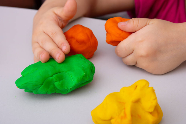 La arcilla colorida en las manos de los niños, preescolar tiene habilidades motoras - Foto, Imagen
