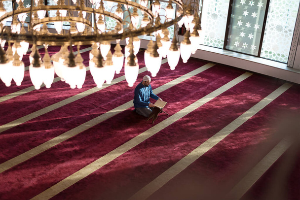 Hombre musulmán leyendo el libro sagrado (Corán) dentro de la mezquita - Foto, Imagen