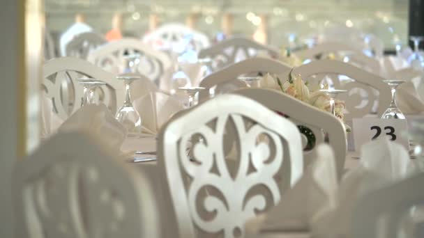 Plaats instellingen, tafels en stoelen zijn leeg voordat de gasten aankomen bij een bruiloft receptie.Eettafels, rond, tafeldecoratie, feestelijk, bedekt. Viering ceremonie decor versieren versierd verfraaien diner elegantie elegante chique maaltijd  - Video