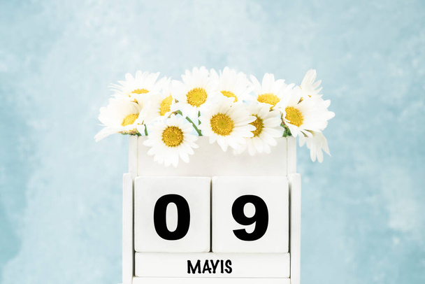 Fehér kocka naptár májusban törökül a százszorszép virágok felett kék háttér másolás hely - Fotó, kép