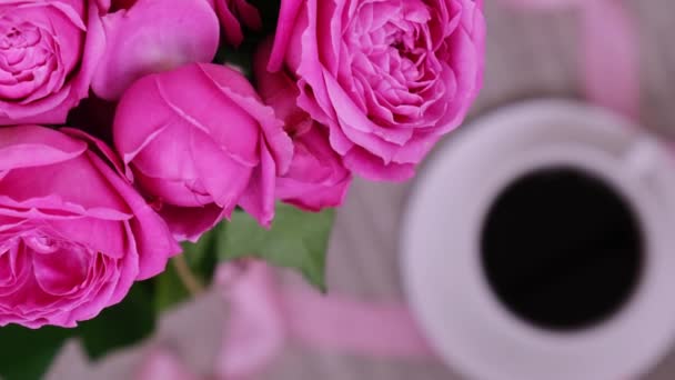 Šálek kávy a růžových růží. Dovolená koncept, kytice růží k narozeninám, kytice květin v ranní snídani. Žena pije cappuccino - Záběry, video
