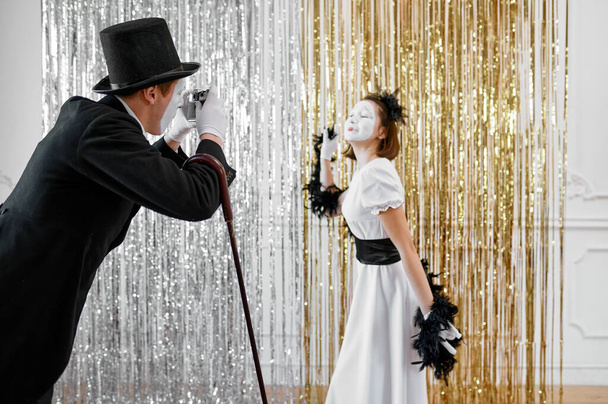 Two mime artists, lady poses at gentleman with camera. Pantomime theater, parody comedian, positive emotion, humour performance, funny face mimic and grimace - Photo, Image