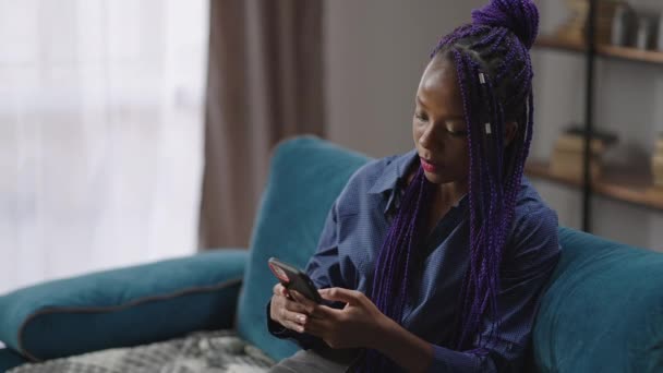 black teen girl is sending messages in social nets by smartphone, modern technology for communicating - Footage, Video