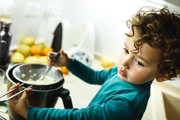 Kislány segít elkészíteni a tortát egy élelmiszer-feldolgozó segítségével. - Fotó, kép