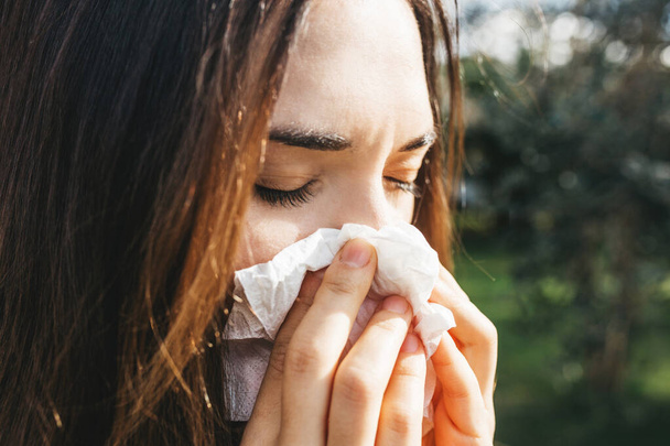 Kobieta wbija nos w chusteczkę. Objaw choroby lub alergii - Zdjęcie, obraz