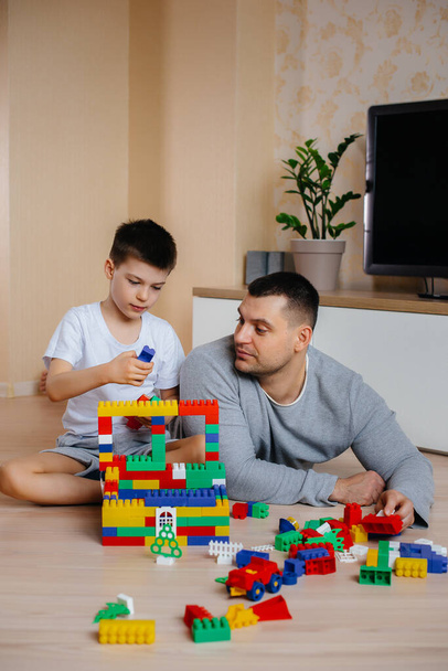 A little boy together with his father is played by a constructor and builds a house. Construction of a family home. - Foto, Imagem