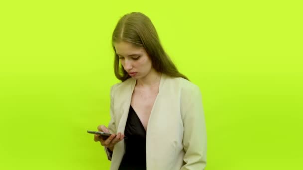 Nainen älypuhelimen pensive selailu uutissyötteen - Materiaali, video