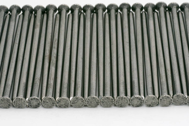 Metal nails neatly stacked on a white background - Photo, Image