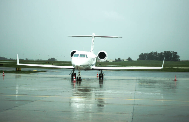 Частный самолет в аэропорту под дождём в Лиссабоне, Португалия - Фото, изображение