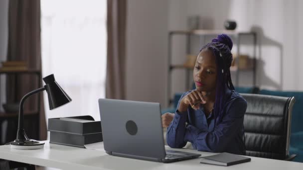 afro-américaine femme est à la recherche sur l'écran de l'ordinateur portable et écoute webinaire d'apprentissage ou conférence en ligne - Séquence, vidéo