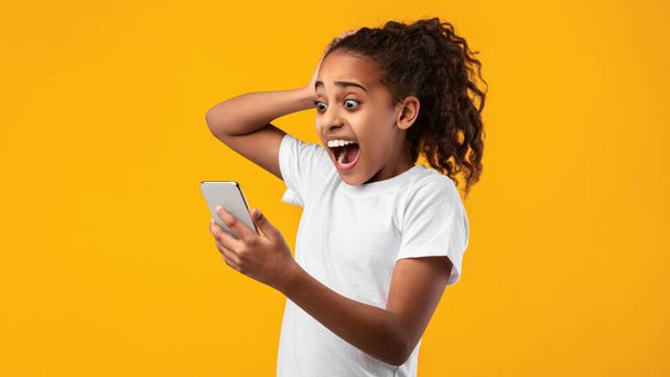 Ansiosa garota negra assustada olhando para o telefone vendo más notícias - Foto, Imagem