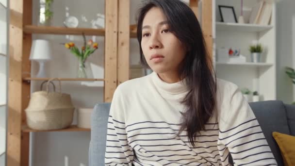 Düşünceli Asyalı kadın oturma odasında dizlerini kucaklayarak oturur kendini yalnız hisseder, üzgün genç kız evde yalnız vakit geçirir, sosyal mesafe, Coronavirüs karantinası.. - Video, Çekim