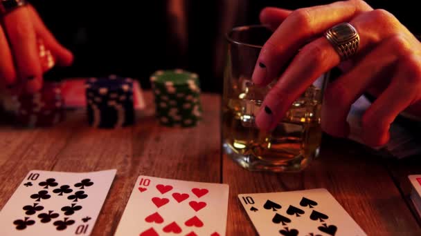 Makroansicht eines Pokerspiels, bei dem ein Mann mit Alkohol an einem Fingerglas klopft und dann mit Chips wirft - Filmmaterial, Video