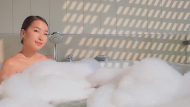 Güzel Asyalı kadının sabun köpüğüyle banyo yaptığı görüntüler. - Video, Çekim