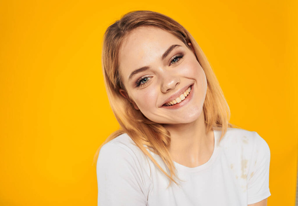 Portrait d'une belle blonde sur fond jaune sourire éblouissant modèle vue recadrée - Photo, image