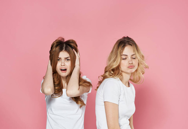 two women in t-shirts fashion glamor communication emotions pink background - Fotoğraf, Görsel