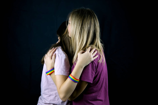 Dvě dívky s LGBT stuhami se objímají. - Fotografie, Obrázek
