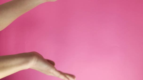 вертикальне відео. жести рук. жінка згинає руки... ізольовані на рожевому тлі. Рекламна концепція
. - Кадри, відео