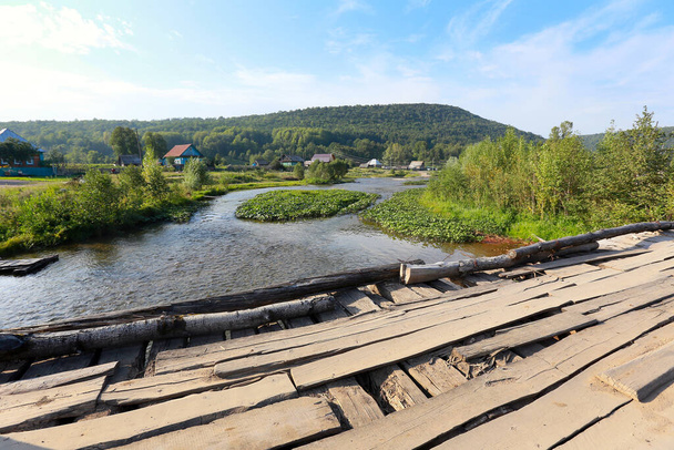 summer landscape old wooden bridge over a small river on a cloudy day - 写真・画像