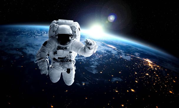 Astronot uzay yürüyüşü yaparken uzay istasyonu için çalışır. - Fotoğraf, Görsel