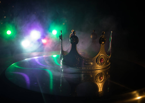 imagen de llave baja de hermosa reina / corona de rey sobre mesa de madera. filtrado vintage. época medieval de fantasía. Enfoque selectivo. Retroiluminación colorida - Foto, Imagen